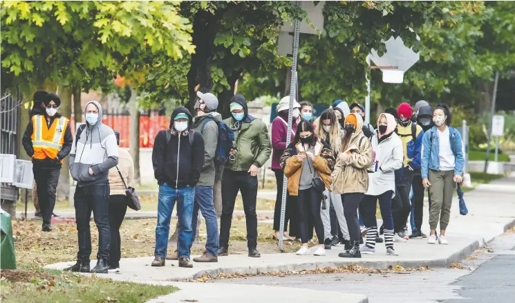  ?? Peter J Thompson / National Post ?? Residents wearing masks wait in line for COVID-19 testing at Toronto’s St. Joseph’s Health Centre on Friday.