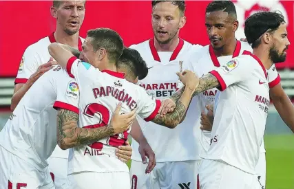  ?? EFE ?? Ocampos y el Papu Gómez se abrazan tras uno de los dos goles que el Sevilla le marcó al Granada