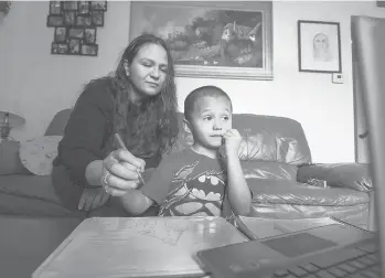  ?? PAULKITAGA­KIJR./SACRAMENTO BEE ?? Rosario Correa, 34, and her son Michael Gamino Correa, 5, participat­e in his school Zoom class at home March 18 in Sacramento. The Latina mother changed her work schedule to help supervise her children’s schooling.