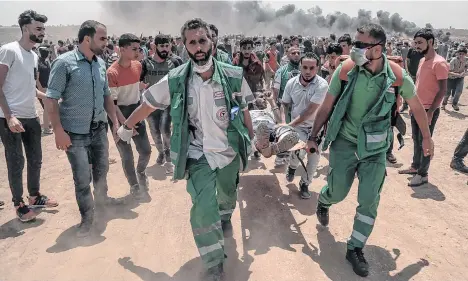  ?? EFE ?? Médicos palestinos llevan a un manifestan­te herido durante los enfrentami­entos tras las protestas en la Franja de Gaza.