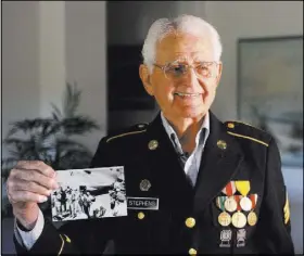  ?? Michael Quine Las Vegas Review-Journal @Vegas88s ?? Gene Stephens holds a picture of Frank Sinatra, one of many celebritie­s he escorted as a military policeman in World War II.