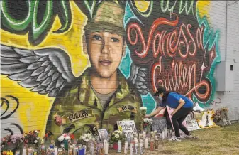  ?? Jay Janner / Austin American-Statesman 2020 ?? Mellisa Mendoza places roses last summer at a memorial for Vanessa Guillen in Austin, Texas. Guillen was killed by a fellow soldier at Fort Hood. Her remains were found two months later.