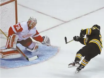  ?? Staffphoto­byJohNWILC­oX ?? MAKING THEM PAY: Austin Czarnik snaps a penalty shot past Red Wings goalie Jared Coreau in the second period of the Bruins’ 4-2 victory last night at the Garden.