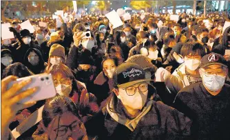  ?? ?? Protesters march along a street during a rally for the victims of a deadly fire as well as a protest against China’s harsh Covid-19 restrictio­ns in Beijing early on Monday.