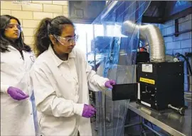  ?? Brian Cassella Chicago Tribune ?? SANJANA PORLURI, left, and Sargun Malik use high-intensity light to kill foodborne pathogens at the Institute for Food Safety and Health in Illinois.