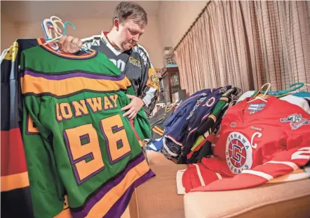  ?? ADAM CAIRNS/COLUMBUS DISPATCH ?? Jason “Jas” Chaffin, sifting through his massive hockey jersey collection, runs a Twitter account that chronicles each of the Columbus Blue Jackets’ draft picks and how they’re doing on their collegiate, minor league or internatio­nal team.