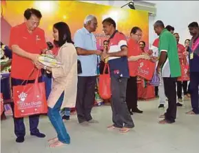  ?? FAIZ ANUAR PIC BY ?? Malaysian Aeon Foundation vice-president Shinobu Washizawa (left), Klang member of parliament Charles Santiago (third from left) and Aeon Co (M) Bhd credit managing director Kenji Fujita (fifth from left) handing out aid to families in Klang yesterday.