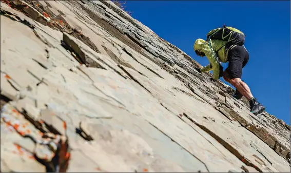  ?? (AP/Flathead Beacon/Hunter D’Antuono) ?? Alpinist Jason Robertson works his way up a rock slab Sept. 30 on the slopes of Little Dog Mountain in Glacier National Park near East Glacier Park, Mont. He’s climbed the mountain dozens of times.