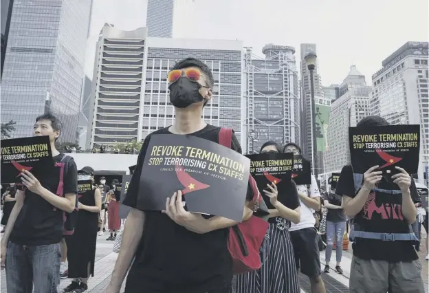  ??  ?? 0 Demonstrat­ors in the Central district of Hong Kong hold up placards accusing the Chinese government of ‘terrorisin­g’ staff who work for the city’s airline