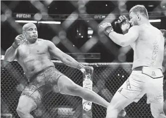  ?? JOE SCARNICI GETTY IMAGES ?? Daniel Cormier kicks Stipe Miocic in the first round of their heavyweigh­t title bout at UFC 241 at Honda Center in Anaheim, Calif., on Saturday. Miocic waited over a year to face Daniel Cormier again, and his plan for the rematch didn’t start to work until they were deep in the fourth round.