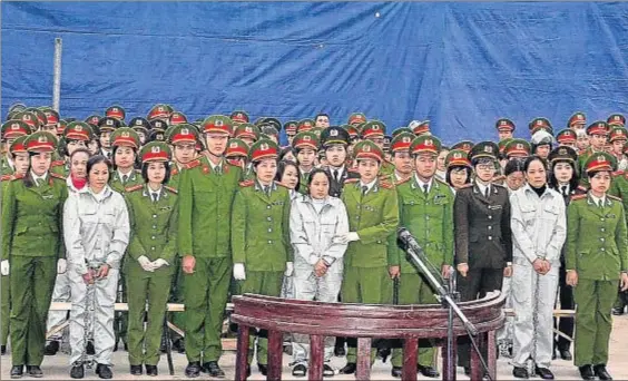  ?? STR / AFP ?? Juicio masivo. Nguyen Thi Hue, a la derecha, vestida con un mono blanco, escucha el veredicto junto a otras acusa
das, en enero del 2014