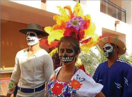  ?? JANET PODOLAK — THE NEWS-HERALD ?? Painted faces of skulls and costumes with a feathered headdress are seen everywhere in Mazatlan during the three-day Day of the Dead celebratio­n.