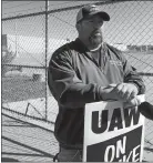  ?? JOHN SEEWER/AP PHOTO ?? Striking General Motors worker Mike Armentrout stands on the picket line last week outside a transmissi­on plant in Toledo, Ohio. Workers say they are starting to feel the pinch of going without their regular paychecks.