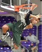  ?? LARRY MCCORMACK/THE TENNESSEAN ?? Kennedy Chandler hangs on the rim after dunking against Ensworth in the Division II-AA semifinals on Feb. 28 in Nashville.