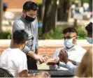  ?? ASHLEE REZIN GARCIA/SUN-TIMES PHOTOS ?? General manager Juan Becerril, 35, of Chicago, dispenses hand sanitizer to customers preparing to eat lunch on the patio at Flat Top Grill in Evanston in May.