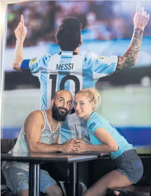  ??  ?? German tourists Oshin Gharibi, left, and Lena Wagner pose for a picture at the bar owned by Lionel Messi’s family in Rosario, Argentina.