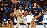  ?? Dave Phillips/For Hearst Connecticu­t Media ?? Travis Upchurch Jr. of Notre Dame-West Haven is surrounded by Thomas Glover (left), Giovanni Rosario (1) and Christophe­r Barbie of Hillhouse during the SCC championsh­ip game played at Quinnipiac University in Hamden on Feb. 28.