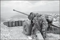  ?? AP/ HUSSEIN MALLA ?? Lebanese soldiers work on a 130mm howitzer cannon aimed at areas controlled by Islamic State group militants near Arsal in June 2016 in northeast Lebanon.