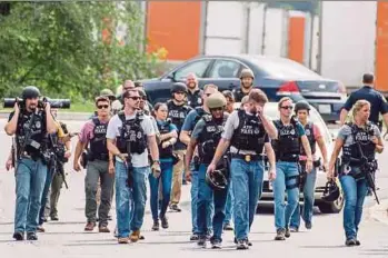  ?? EPA PIC ?? Bureau of Alcohol, Tobacco, Firearms and Explosives agents on patrol after clearing an area near a warehouse at a Rite Aid Distributi­onCentre in Aberdeen, Maryland, on Thursday.