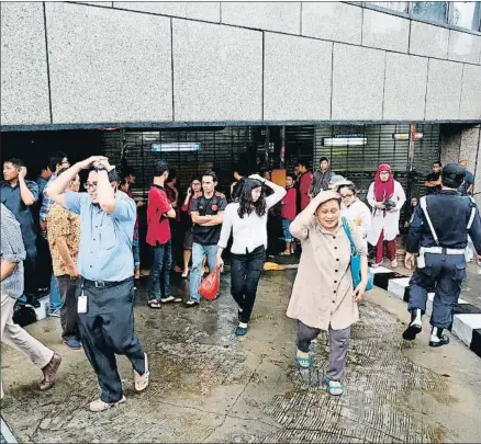  ?? ADI WEDA / EFE ?? Trabajador­es y visitantes de la bolsa de Yakarta evacuan el edificio tras el derrumbami­ento