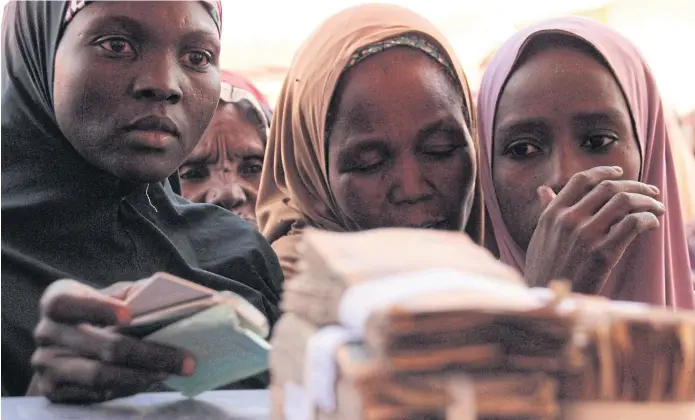  ??  ?? ESCAPE FROM REALITY: Women queue for WFP-distribute­d cash in Maiduguri. Life for Boko Haram brides was a far cry from the deep-rooted patriarchy in Nigeria’s mainly Muslim northeast.