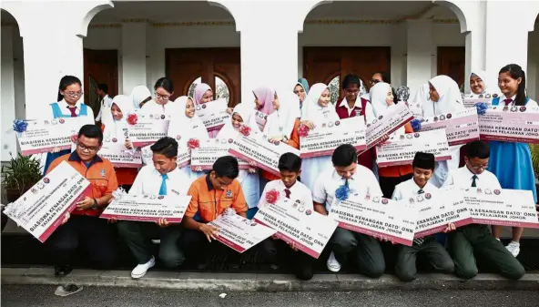  ??  ?? Welcome aid: Kenangan Dato Onn scholarshi­p recipients posing with mock cheques.