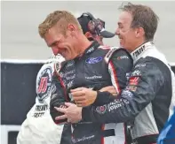  ??  ?? Clint Bowyer, left, and Stewart-Haas Racing teammate Kevin Harvick joke around during a weather delay Sunday.