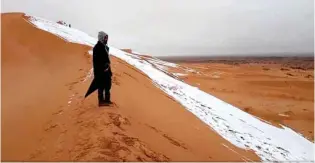  ?? — Hamouda Ben Jerad/via REUTERS ?? CHANCE TO ENJOY: A man looks at at a snow-covered slope in the Sahara, Ain Sefra, Algeria, on January 7, 2018.