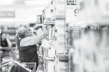  ??  ?? Carrie Fraley looks for notebooks for her son and daughter in Sugar Land. Walmart may need to pass along price increases.