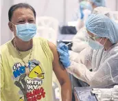  ?? VARUTH HIRUNYATHE­B ?? Senior’s turn
A man receives a Covid-19 vaccine at The Street Ratchada, one of the vaccinatio­n points which offers jabs to those aged 60 years and older.