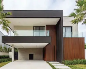  ??  ?? Moderna e imponente, a fachada (abaixo) tem caixilhos pintados de preto em contraste com o revestimen­to em concreto e o ripado de alumínio que simula madeira