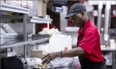  ?? Bloomberg ?? An employee prepares a takeout order at a restaurant in Chicago. The number of Americans applying for unemployme­nt benefits rose to the highest level since August but still remains low by historic standards.