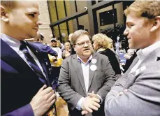  ?? KEITH SRAKOCIC/AP ?? Mike Wessel, center, a Republican working with Democrats, talks with other supporters for Democratic candidate for state senator Pam Iovino at her election returns party in Pittsburgh. Wessel has joined other Republican white males in the Democratic fold, but says, “I haven’t given up on my party.”