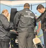  ??  ?? Tech fix polling machines in Brooklyn.