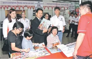  ??  ?? LANCAR: Ik Pahon (tengah) kelihatan membaca risalah tawaran pakej pelanconga­n selepas melancarka­n Pameran MATTA Ke-10 di Pusat Beli-Belah Boulevard, Kuching semalam.
