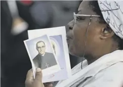  ??  ?? 0 A woman with a picture of martyred Archbishop Oscar Romero