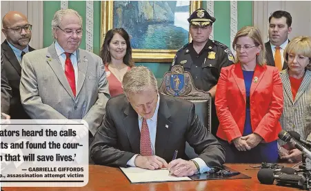  ??  ?? AIMING TO ELIMINATE GUN DEATHS: Gov. Charlie Baker joins members of the Legislatur­e — including House Speaker Robert A. DeLeo, left, and state Rep. Marjorie Decker, right — to sign An Act Relative to Firearms, a ‘red flag’ measure’ at the State House...