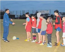  ??  ?? Trainer Abdullah Al Haj Fares erklärt den Kindern die nächste Trainingsa­ufgabe.