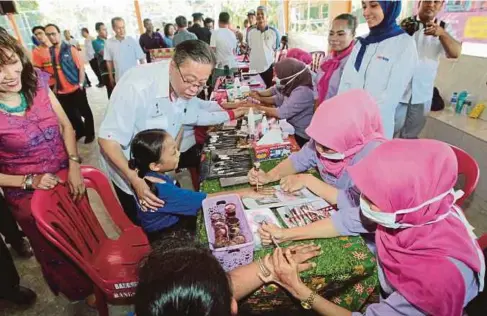 ??  ?? ISMAIL diiringi Pengerusi Persatuan Wanita Siam Negeri Kelantan, KC Ngiam A/P Eh Kuan (kiri) beramah mesra dengan masyarakat Siam.