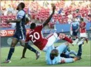  ?? STEVE HAMM — THE ASSOCIATED PRESS ?? FC Dallas’ Roland Lamah tumbles over with Vancouver Whitecaps FC goalie David Ousted last Saturday. Dallas visits the Union tonight.