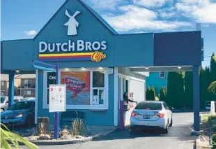  ?? SELSKY/AP ANDREW ?? An employee of Dutch Bros Coffee in Salem, Ore., hands a drink to a customer on Sept. 15, 2021.