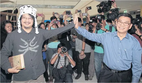  ?? TAWATCHAI KEMGUMNERD ?? Anti-coup activist Sombat Boonngam-anong and fired election commission­er Somchai Srisutthiy­akorn greet each other at the Government Complex on Chaeng Watthana Road yesterday. Mr Sombat was there to register his new political party called the Grin Party...