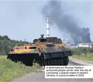  ??  ?? A destroyed pro-Russian fighters’ armoured people carrier near the city of Lisichansk, Luhansk region in eastern Ukraine, in a picture taken in 2014
