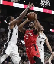  ?? ERIC GAY — THE ASSOCIATED PRESS ?? The Raptors’ Kawhi Leonard, center, is blocked as he drives against the Spurs’ DeMar DeRozan, left, and Derrick White. Leonard scored 21 points in a 125-107 homecoming loss.