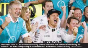  ??  ?? Mercedes’ Formula One driver Nico Rosberg (centre) celebrates with his team after winning the Formula One world championsh­ip at the Yas Marina Circuit in Abu Dhabi on Sunday. –