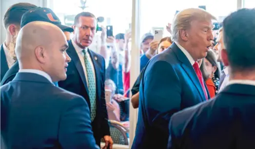  ?? ALEX BRANDON/AP ?? Former President Donald Trump’s valet Walt Nauta (left) watches Tuesday as Trump greets supporters at Versailles restaurant in Miami.