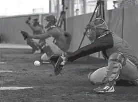  ?? SAM GREENE/CINCINNATI ENQUIRER/USA TODAY SPORTS ?? Pitchers and catchers work in the bullpen at the Reds Player Developmen­t Complex in Goodyear, Ariz.