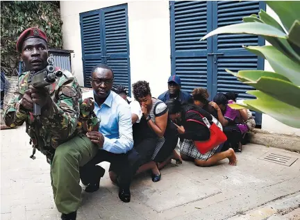  ?? REUTERS ?? PEOPLE ARE evacuated by a member of security forces at the scene where explosions and gunshots were heard at the Dusit hotel compound, in Nairobi, Kenya, Jan. 15.