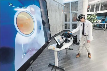  ?? MATHEW MCCARTHY WATERLOO REGION RECORD ?? Quinton Yau, an optometry student at the University of Waterloo, looks through a virtual reality headset which is part of a system that allows students to see a variety of eye diseases.