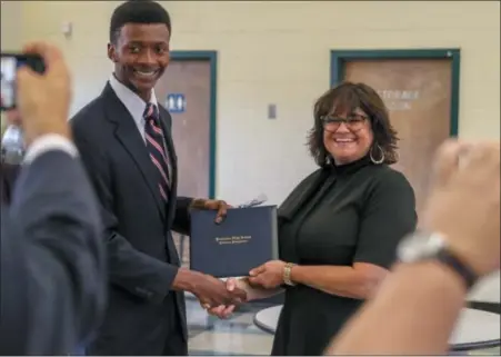  ?? EMILY OVERDORF — FOR DIGITAL FIRST MEDIA ?? Jacob Howard, the first student to earn his high school diploma through Pottstown’s Beech Street Learning Studio program, is congratula­ted by High School Principal Danielle McCoy amid a cluster of cameras.
